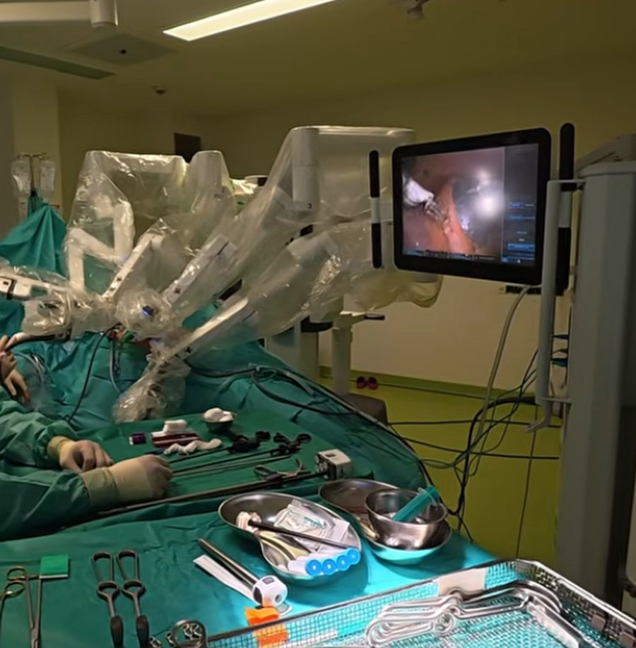 Roboterarme über dem Patienten, daneben ein Bildschirm für das Team